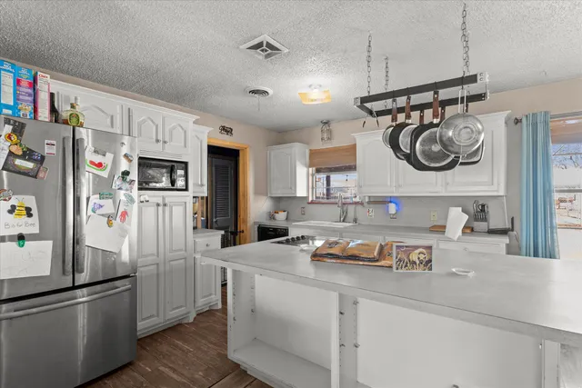 a kitchen with stainless steel appliances granite countertop a refrigerator and a sink
