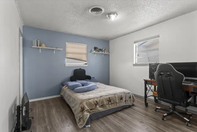 a bedroom with a bed and wooden floor