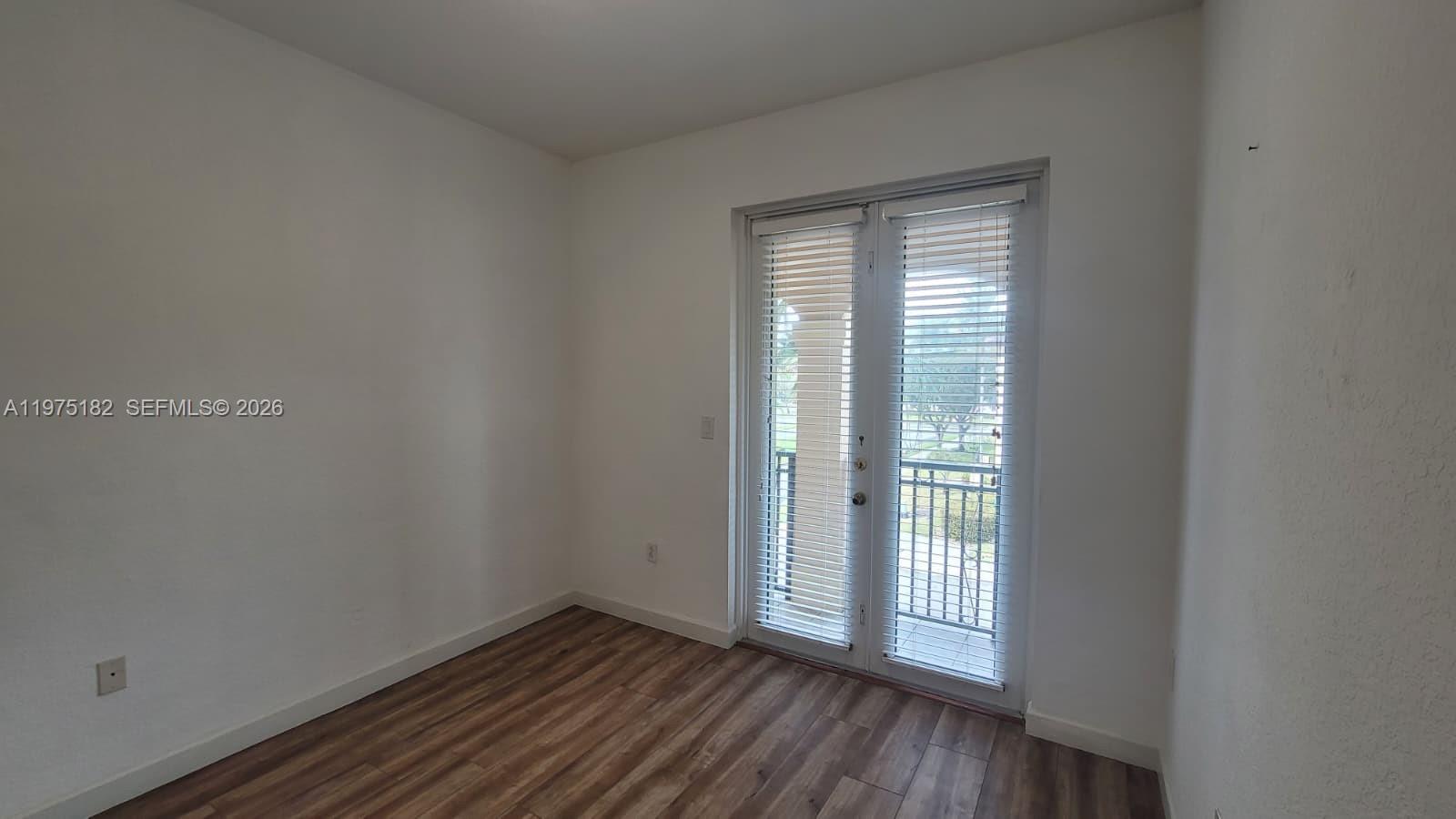 12842 Southwest 134th Street Miami, FL 33186 - Photo 15 of 22 a view of an empty room with wooden floor and a window