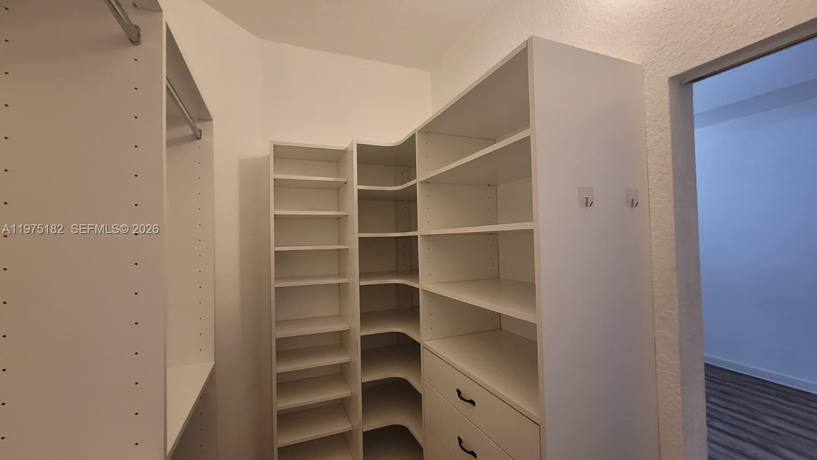 12842 Southwest 134th Street Miami, FL 33186 - Photo 16 of 22 a view of walk in closet with empty racks
