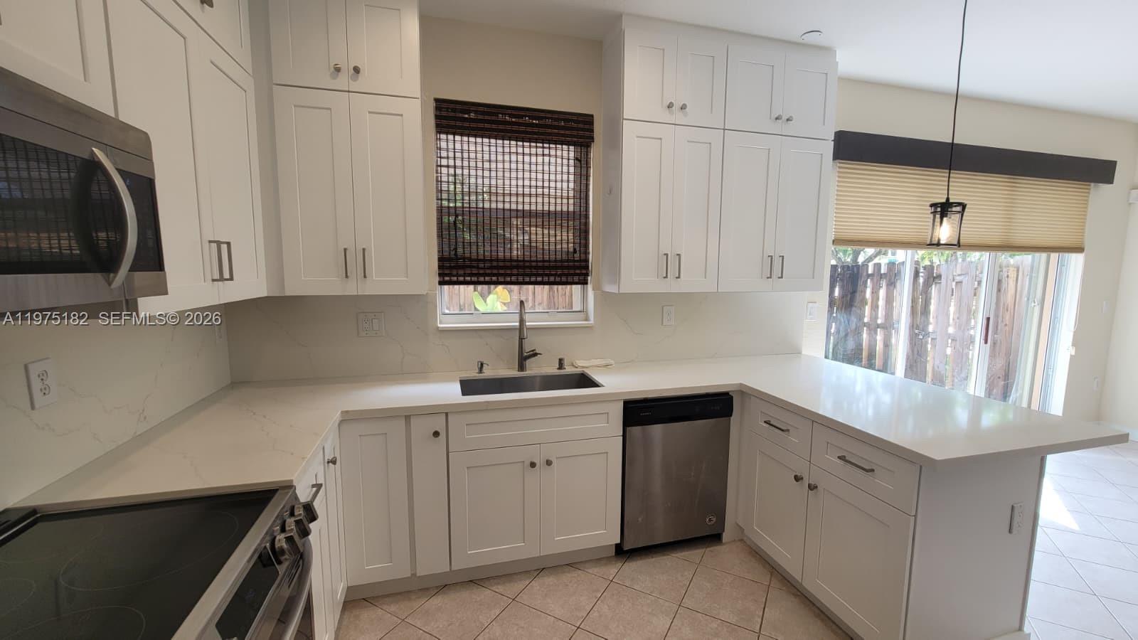 12842 Southwest 134th Street Miami, FL 33186 - Photo 4 of 22 a kitchen with cabinets appliances a sink and a window
