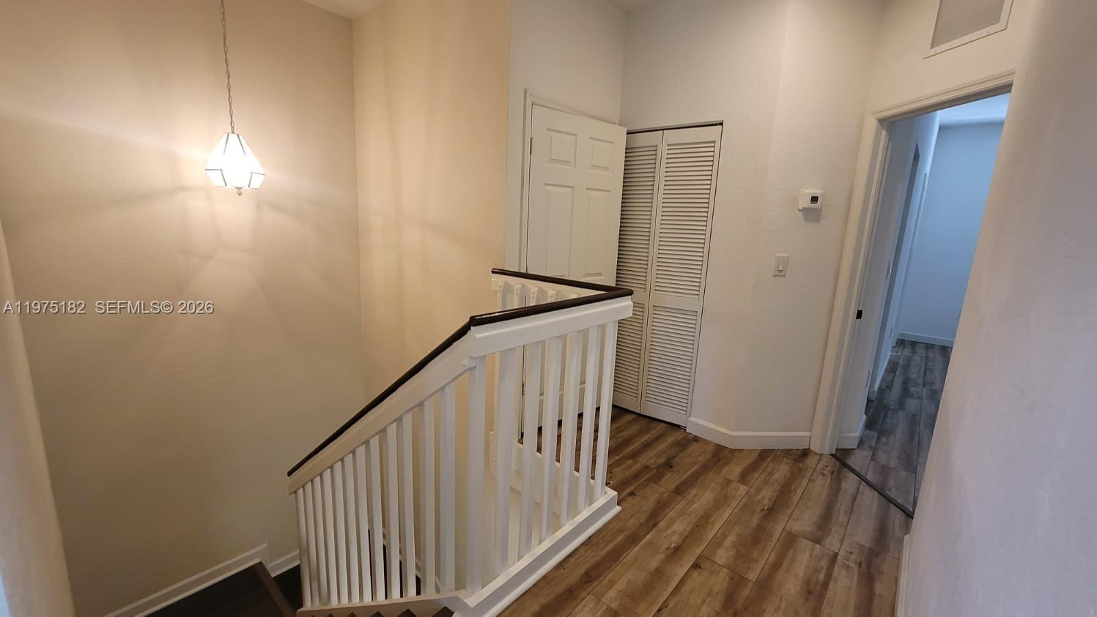12842 Southwest 134th Street Miami, FL 33186 - Photo 8 of 22 a view of a hallway with wooden floor and staircase