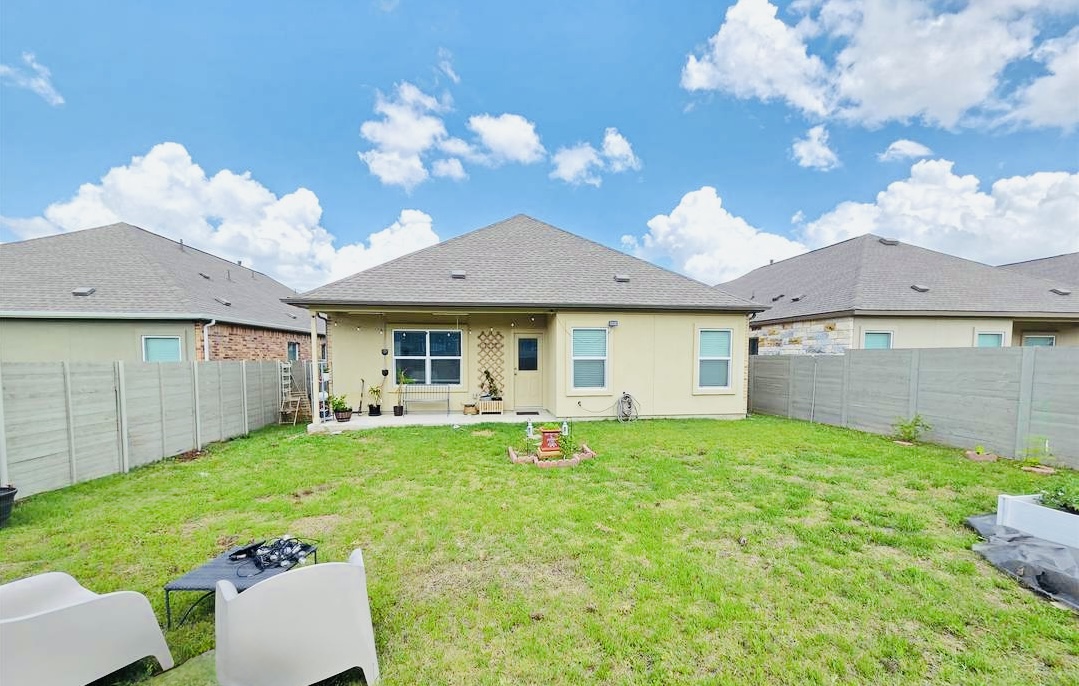 208 Wolf Springs Road Georgetown, TX 78628 - Photo 25 of 32 A well-maintained lawn stretches towards a home with a comfortable covered patio, ready for outdoor enjoyment.