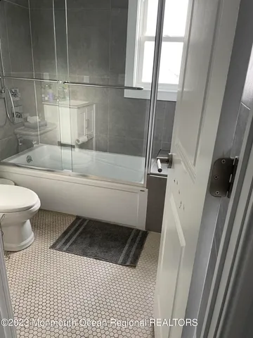 a bathroom with a sink a toilet a tub and shower