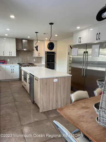 a large kitchen with stainless steel appliances kitchen island granite countertop a sink and cabinets