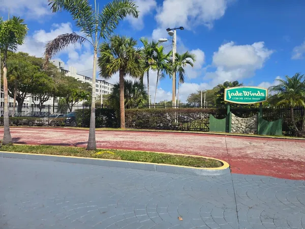 a view of swimming pool with a yard and palm trees