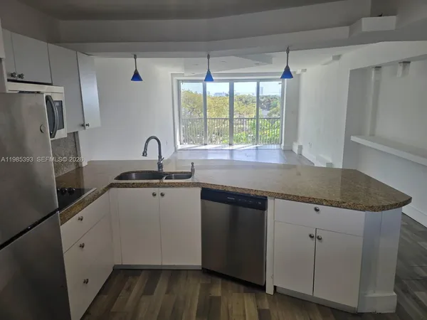 a kitchen with a refrigerator and a stove top oven