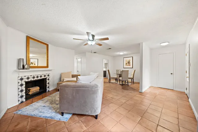 a living room with furniture and a dining table with fireplace