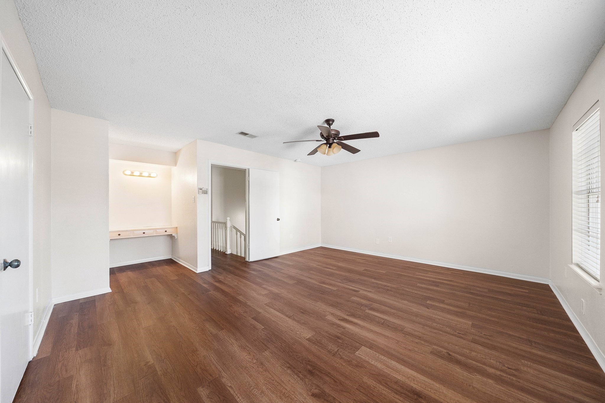 17116 Beaver Springs Drive, Unit 7 Houston, TX 77090 - Photo 7 of 14 a view of empty room with wooden floor and fan