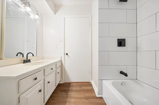 a bathroom with a tub sink and mirror