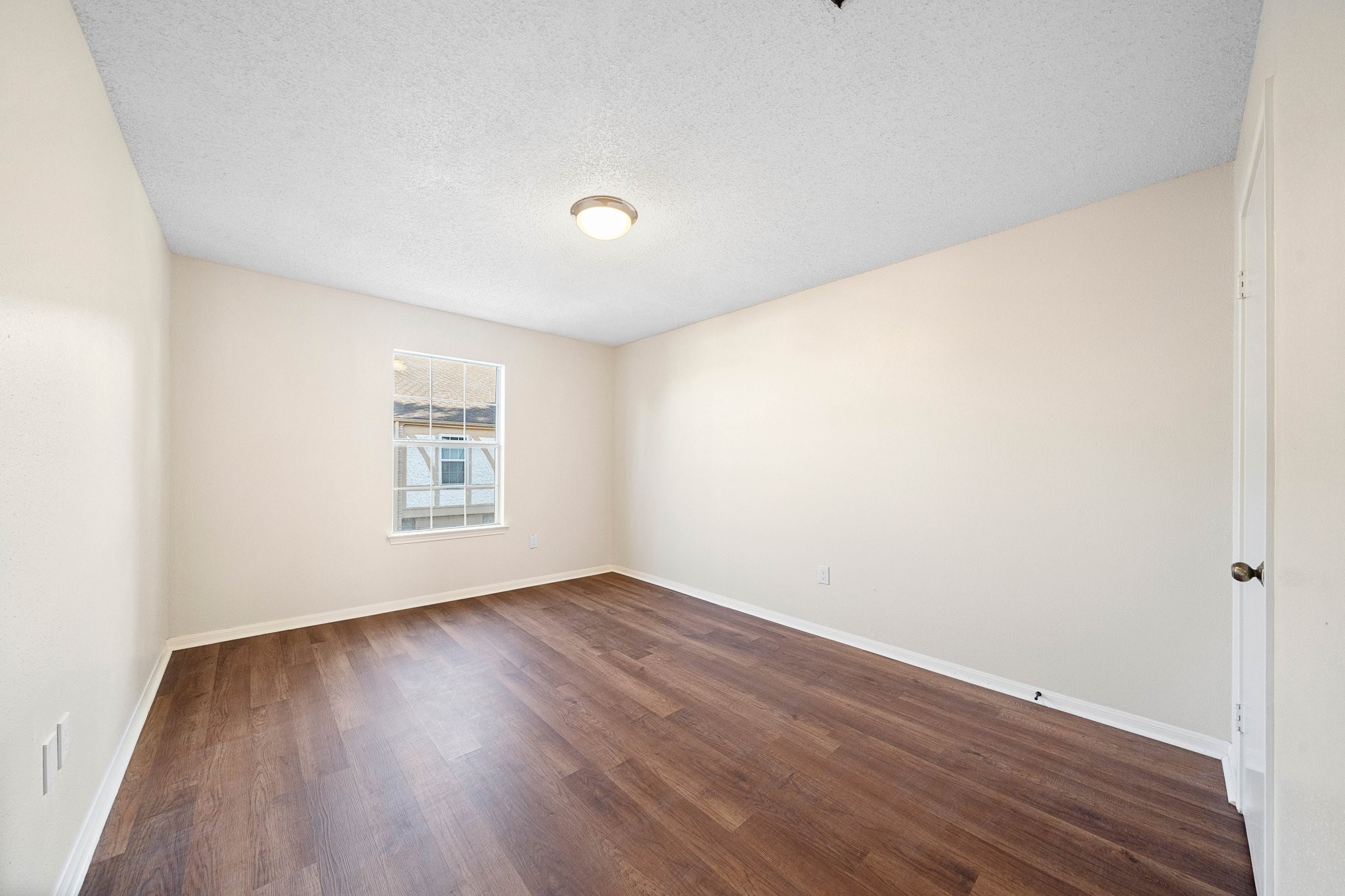 17116 Beaver Springs Drive, Unit 7 Houston, TX 77090 - Photo 9 of 14 an empty room with wooden floor and windows