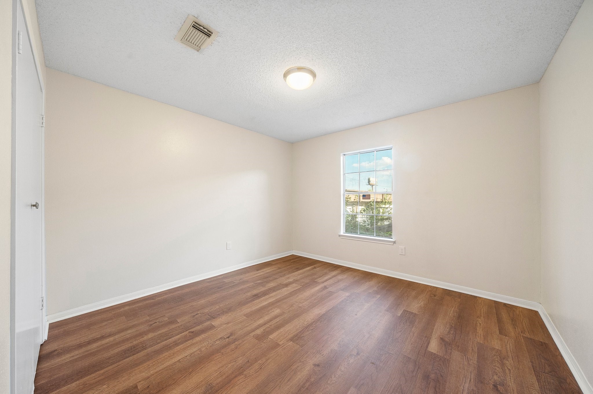 17116 Beaver Springs Drive, Unit 7 Houston, TX 77090 - Photo 10 of 14 an empty room with wooden floor and windows