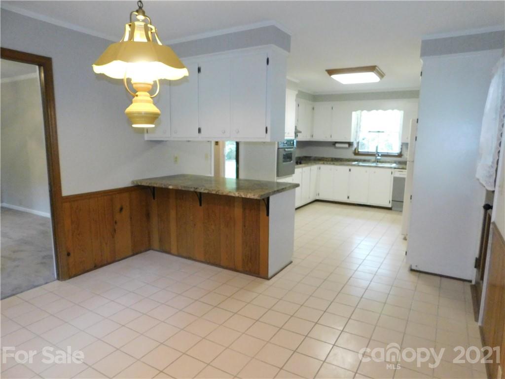 2136 Sunset Road Charlotte, NC 28216 - Photo 11 of 34 a kitchen with stainless steel appliances granite countertop a refrigerator a sink dishwasher and white cabinets with wooden floor