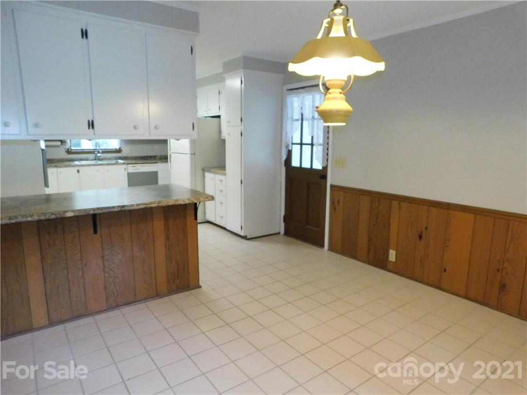 2136 Sunset Road Charlotte, NC 28216 - Photo 12 of 34 a kitchen with stainless steel appliances granite countertop a refrigerator a sink dishwasher and white cabinets with wooden floor