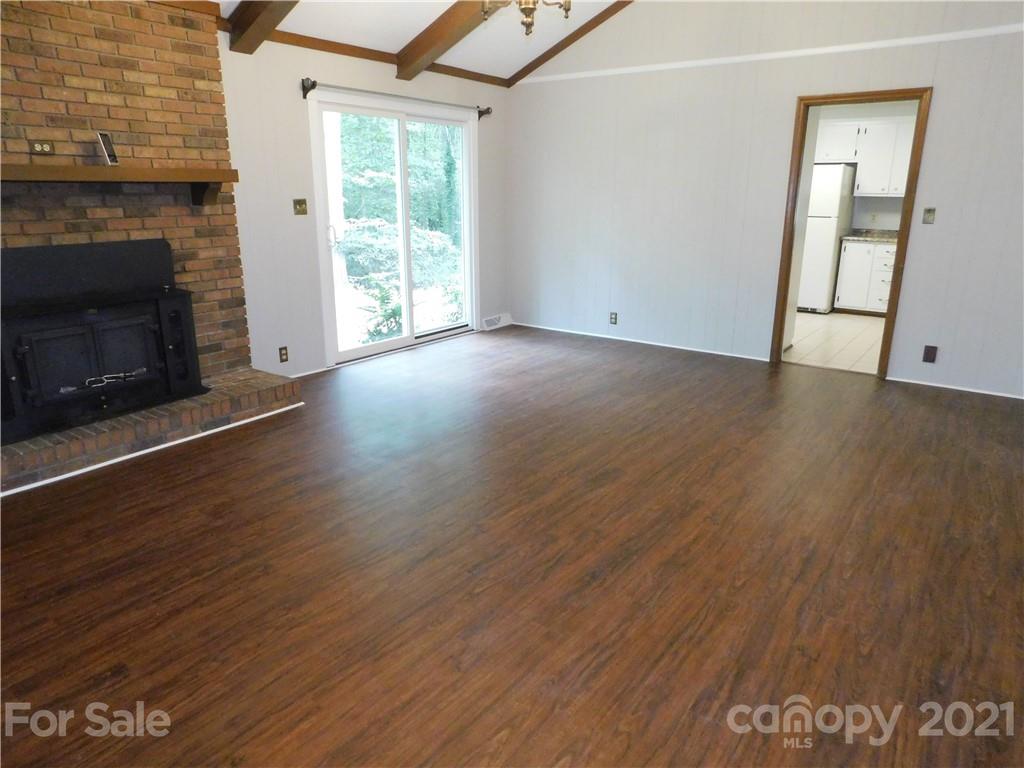 2136 Sunset Road Charlotte, NC 28216 - Photo 17 of 34 an empty room with wooden floor fireplace and windows