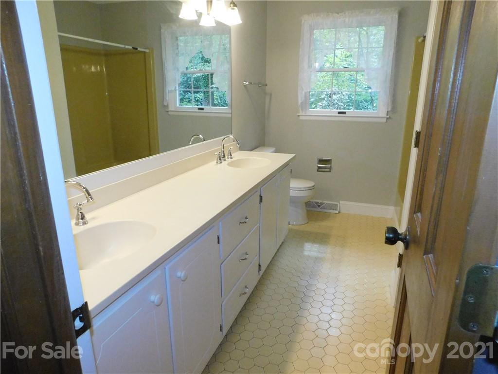 2136 Sunset Road Charlotte, NC 28216 - Photo 22 of 34 a bathroom with a sink a toilet and a mirror