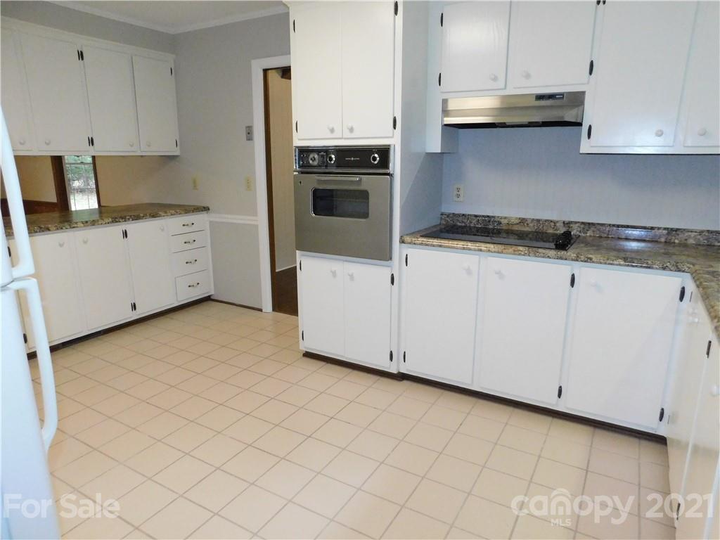 2136 Sunset Road Charlotte, NC 28216 - Photo 8 of 34 a kitchen with granite countertop white cabinets and white appliances