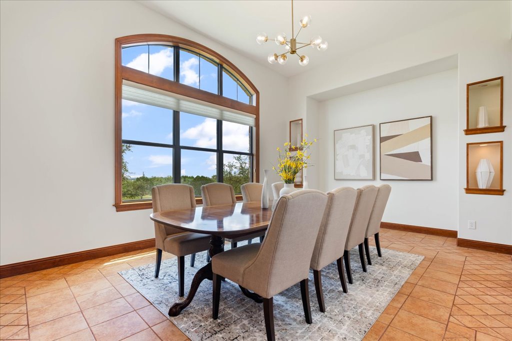1525 Springlake Drive Dripping Springs, TX 78620 - Photo 20 of 38 a view of a dining room with furniture a chandelier and wooden floor