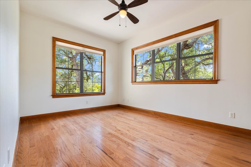 1525 Springlake Drive Dripping Springs, TX 78620 - Photo 22 of 38 a view of an empty room with wooden floor and a window