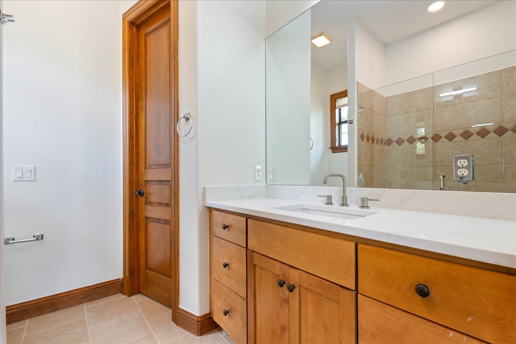 1525 Springlake Drive Dripping Springs, TX 78620 - Photo 23 of 38 a bathroom with a granite countertop sink and a mirror