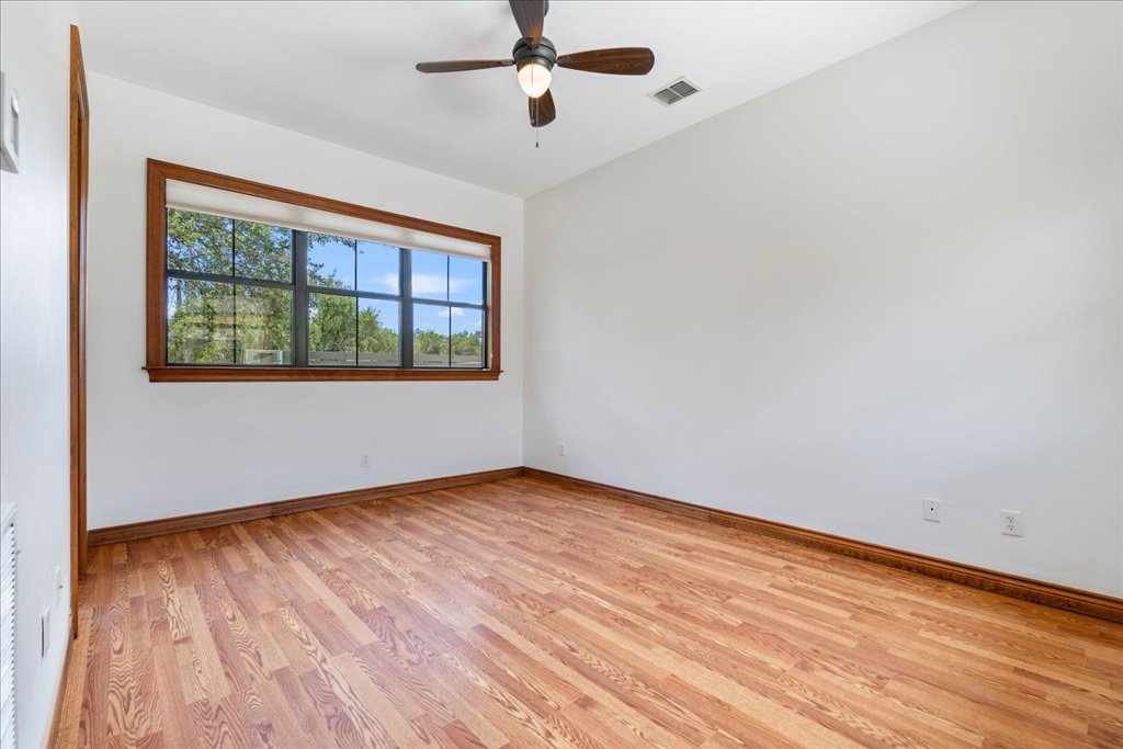 1525 Springlake Drive Dripping Springs, TX 78620 - Photo 24 of 38 an empty room with wooden floor fan and windows