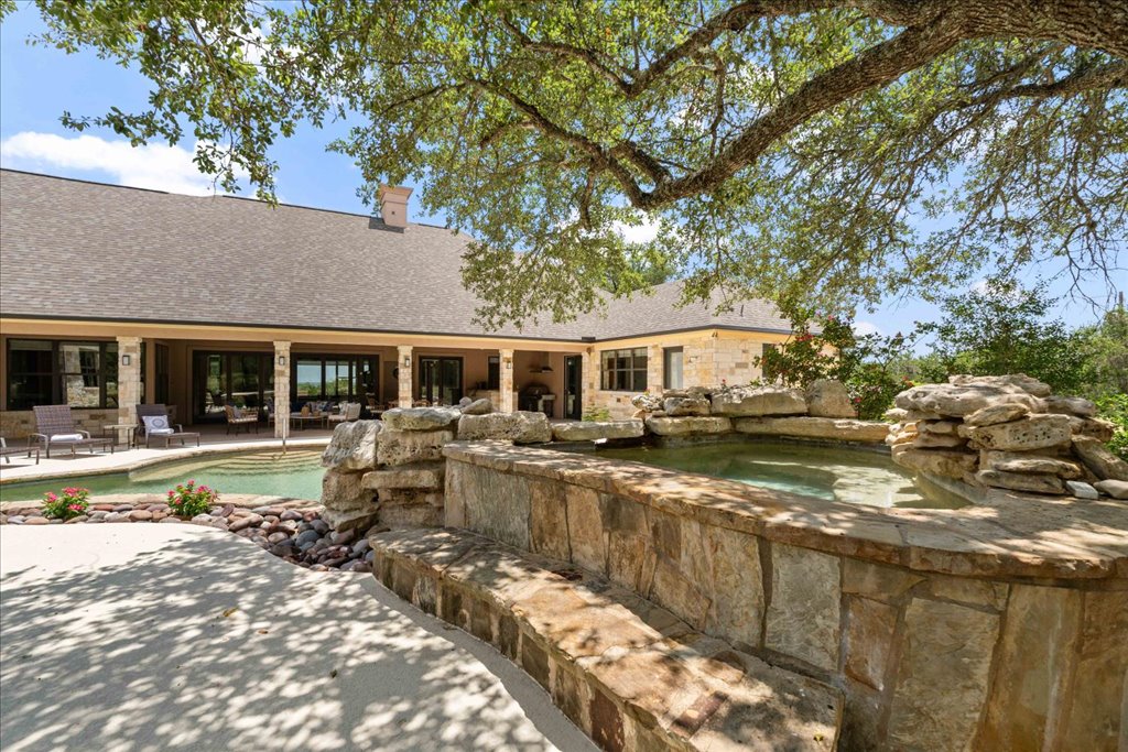 1525 Springlake Drive Dripping Springs, TX 78620 - Photo 28 of 38 a view of house with swimming pool outdoor seating