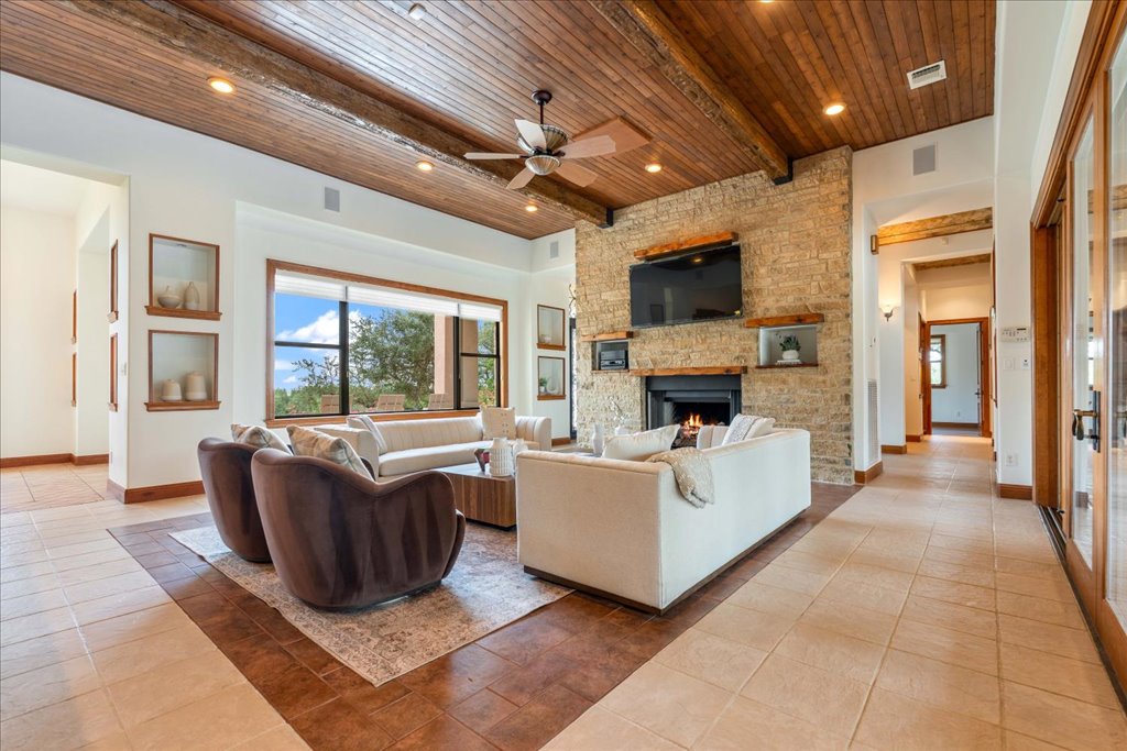 1525 Springlake Drive Dripping Springs, TX 78620 - Photo 7 of 38 a living room with furniture a fireplace and a flat screen tv
