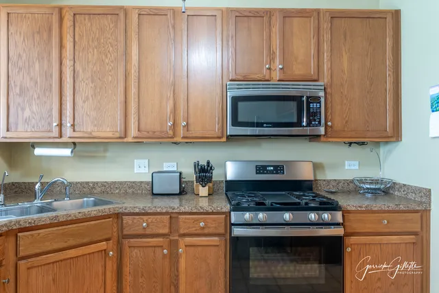 a kitchen with granite countertop white cabinets and stainless steel appliances