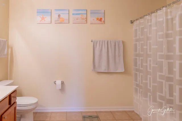 a bathroom with a toilet and a shower curtain