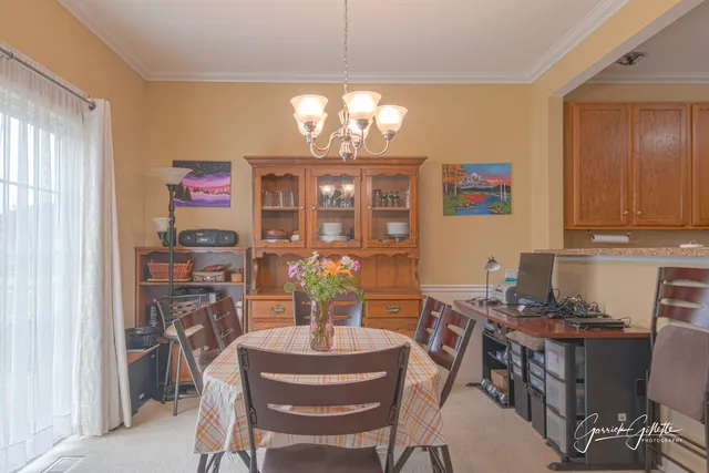 a view of a dining room with furniture and chandelier