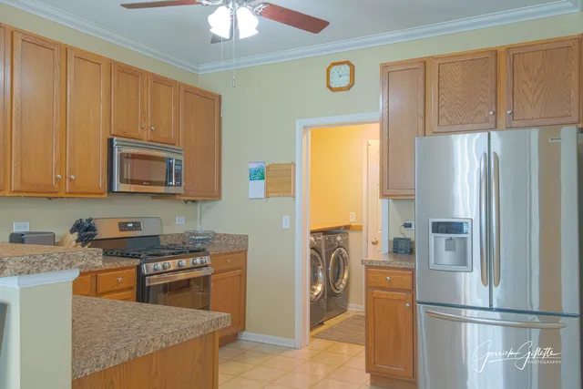 a kitchen with stainless steel appliances granite countertop a refrigerator a stove and a sink