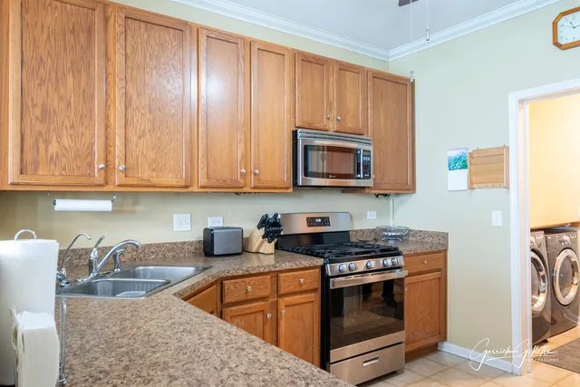 a kitchen with stainless steel appliances granite countertop a stove a sink and a microwave