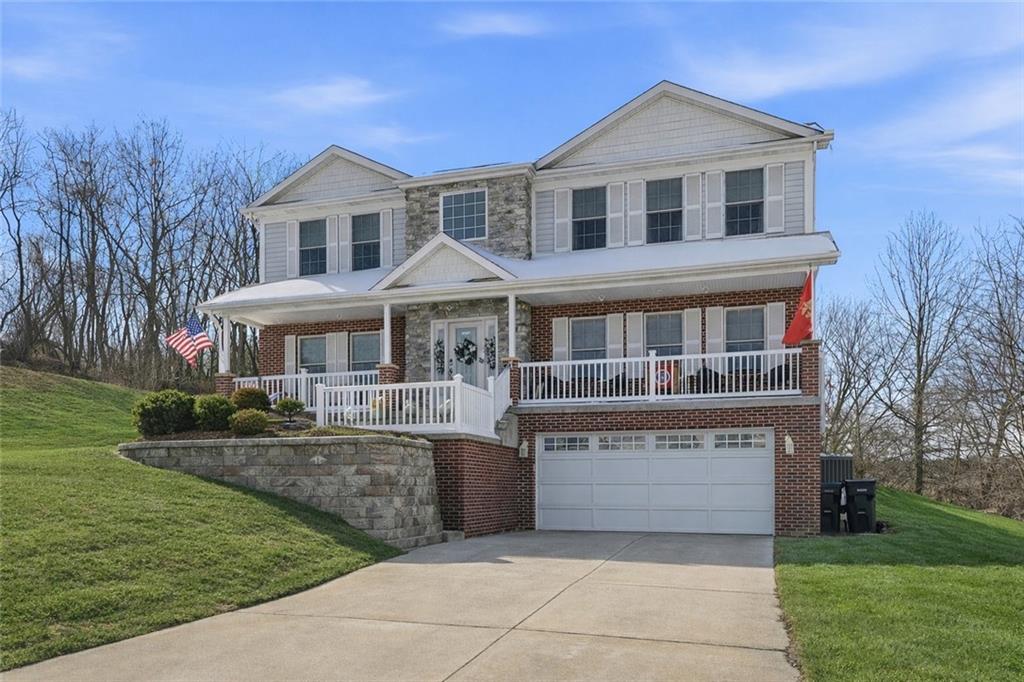 a front view of a house with a yard and trees