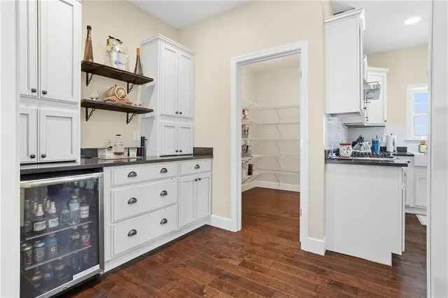 a kitchen with stainless steel appliances cabinets and a wooden floor