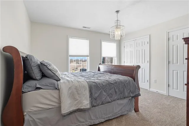a bedroom with a bed chandelier and window