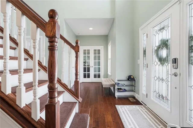 a view of a hallway with wooden floor and staircase