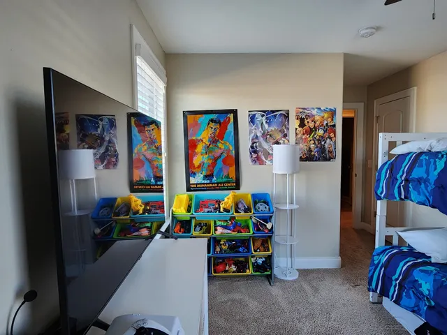 a bedroom with a bed and painting on the wall