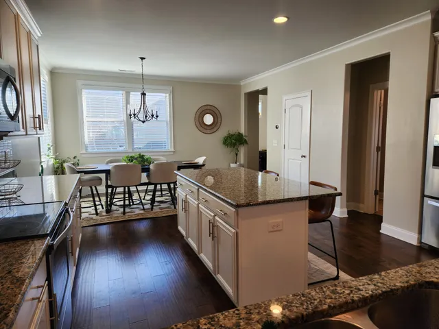 a kitchen with stainless steel appliances granite countertop a sink stove and wooden floor