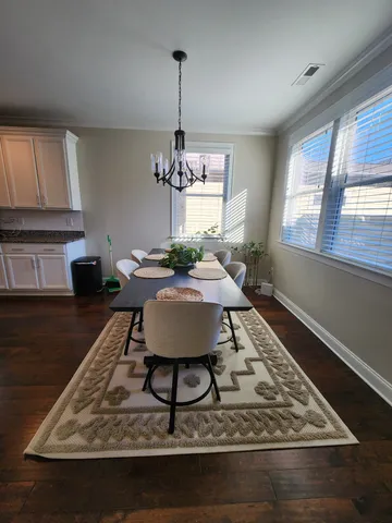 a living room with dining table a rug and a window