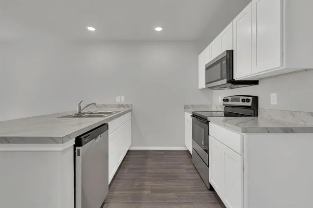a kitchen with microwave cabinets and stove top oven