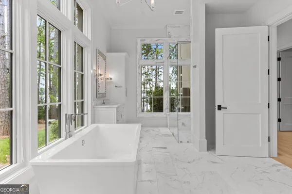 a view of a brick house with large windows and plants