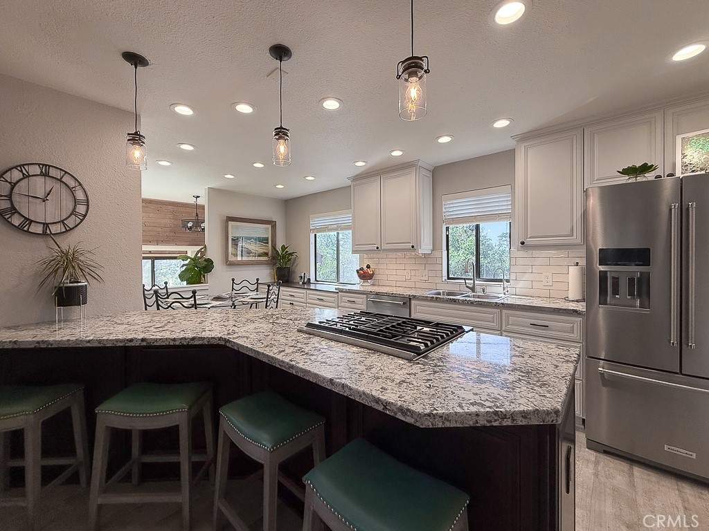 2298 Tipton Street Cambria, CA 93428 - Photo 17 of 54 a kitchen with granite countertop kitchen island stainless steel appliances a sink and a refrigerator