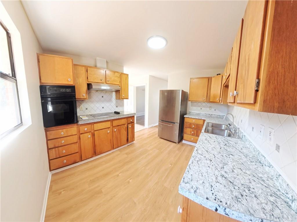 3881 Pin Oak Circle Atlanta, GA 30340 - Photo 20 of 26 a kitchen with stainless steel appliances kitchen island granite countertop a refrigerator stove oven and white cabinets with wooden floor
