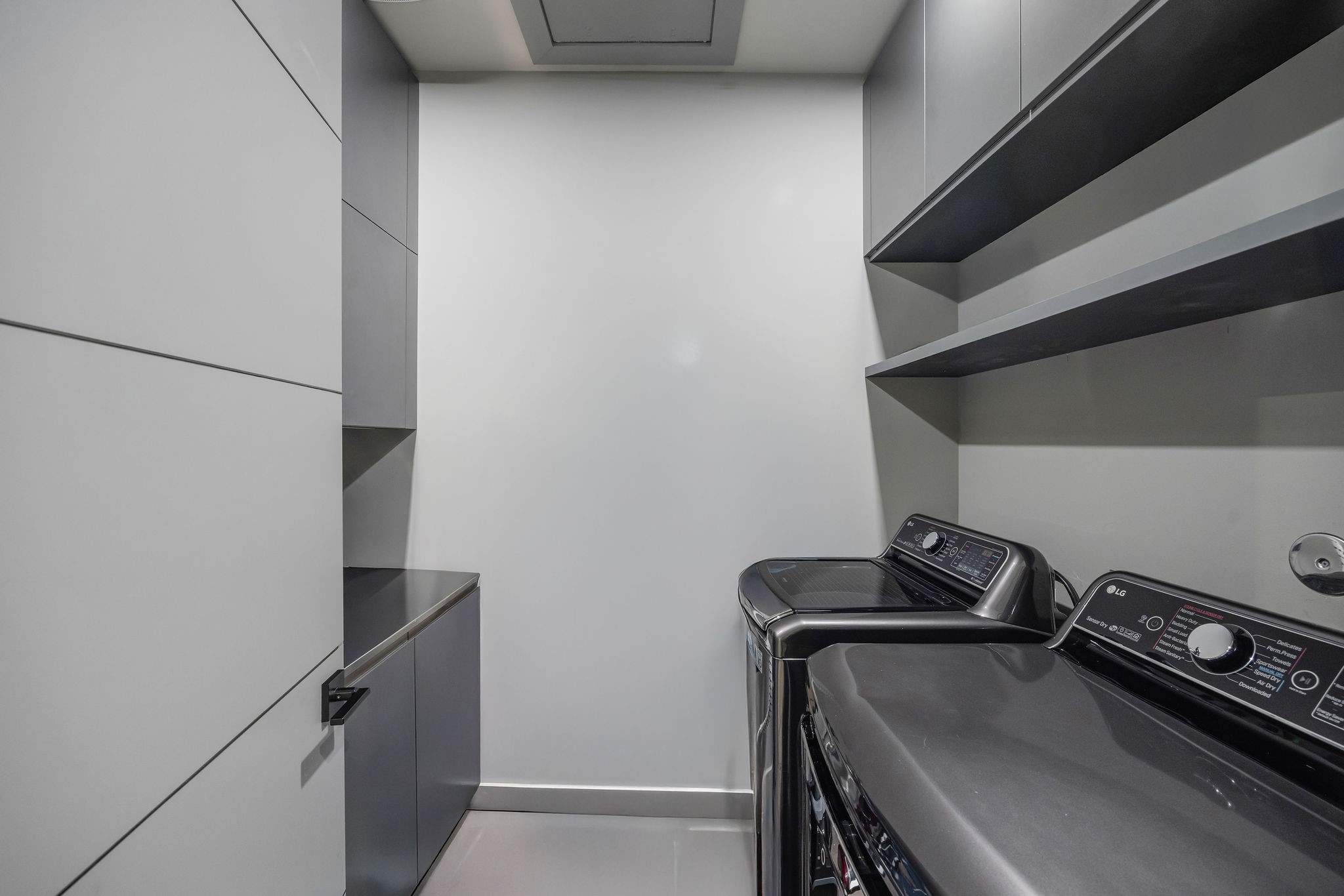 908 White Street Houston, TX 77007 - Photo 17 of 21 Utility room with built-in cabinetry, shelving, and full-size washer and dryer.