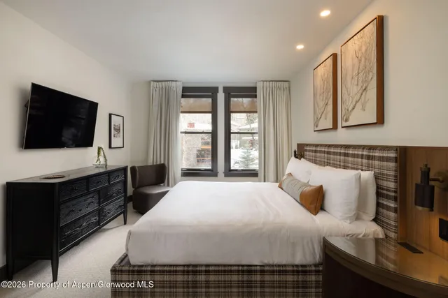 a bedroom with a large bed and a flat screen tv