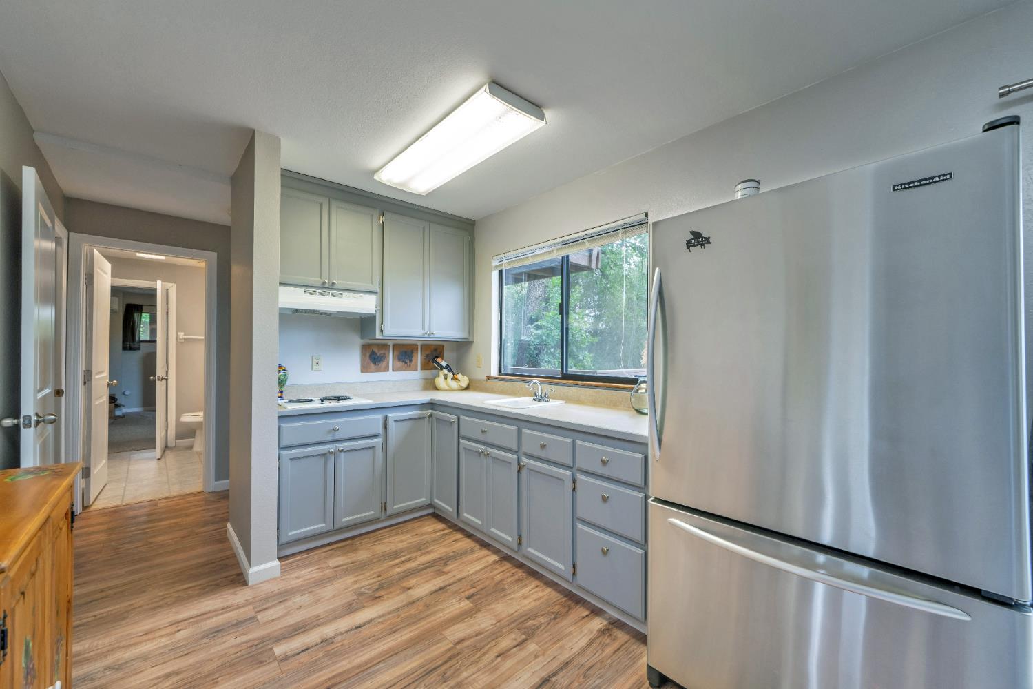 3041 Rising Hill Court Placerville, CA 95667 - Photo 13 of 31 a kitchen with stainless steel appliances granite countertop a refrigerator a sink dishwasher a stove and white countertops with wooden floor