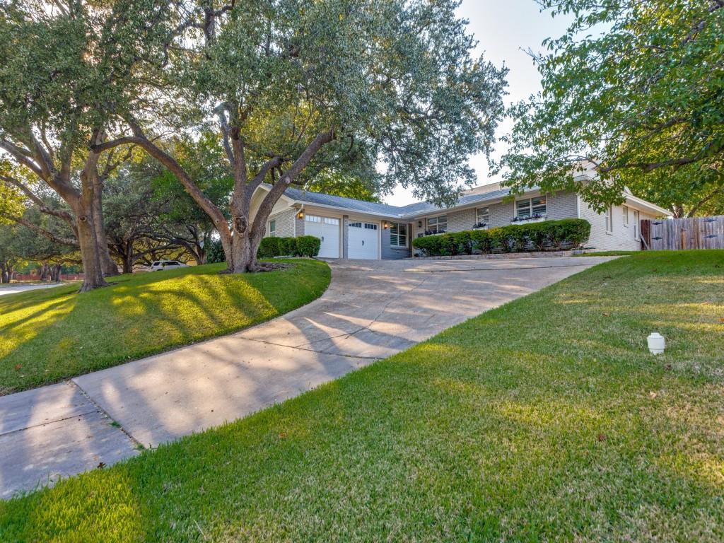 a front view of a house with a yard and trees