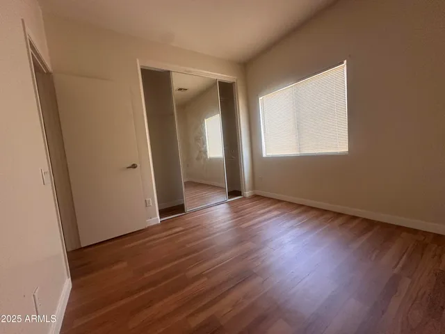 an empty room with wooden floor and a window