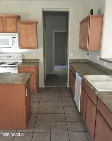 a kitchen with granite countertop a sink stove and cabinets