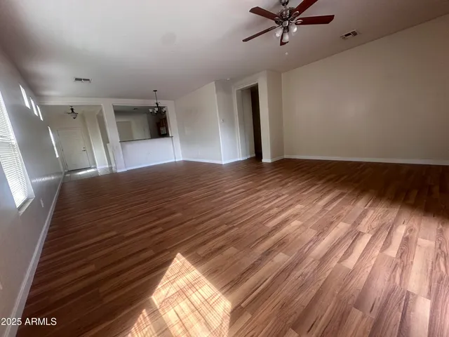 a view of a livingroom with a ceiling fan and wooden floor